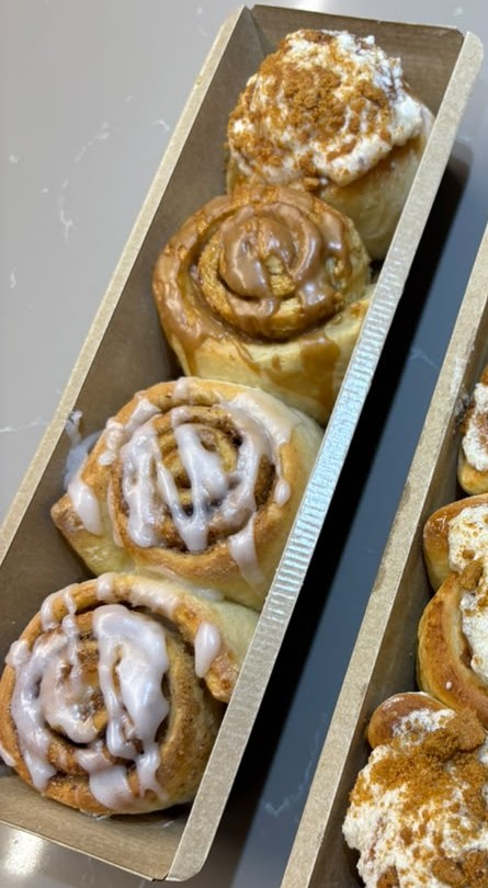 A box of four Bun Intended buns in their kraft tray: Lotus, caramel and classic cinnamon