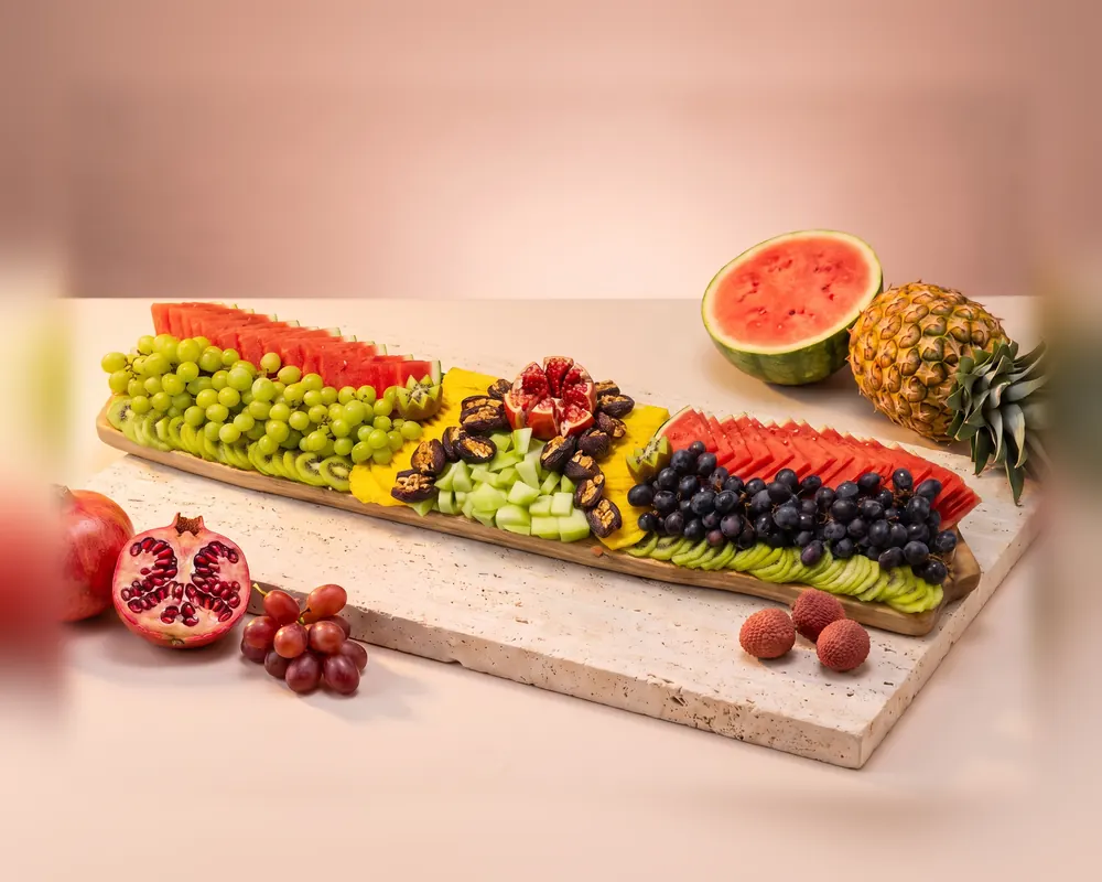 The Extra large platter: a very long board in rows of green grapes, watermelon, dates, pomegranate, dark grapes and kiwi
