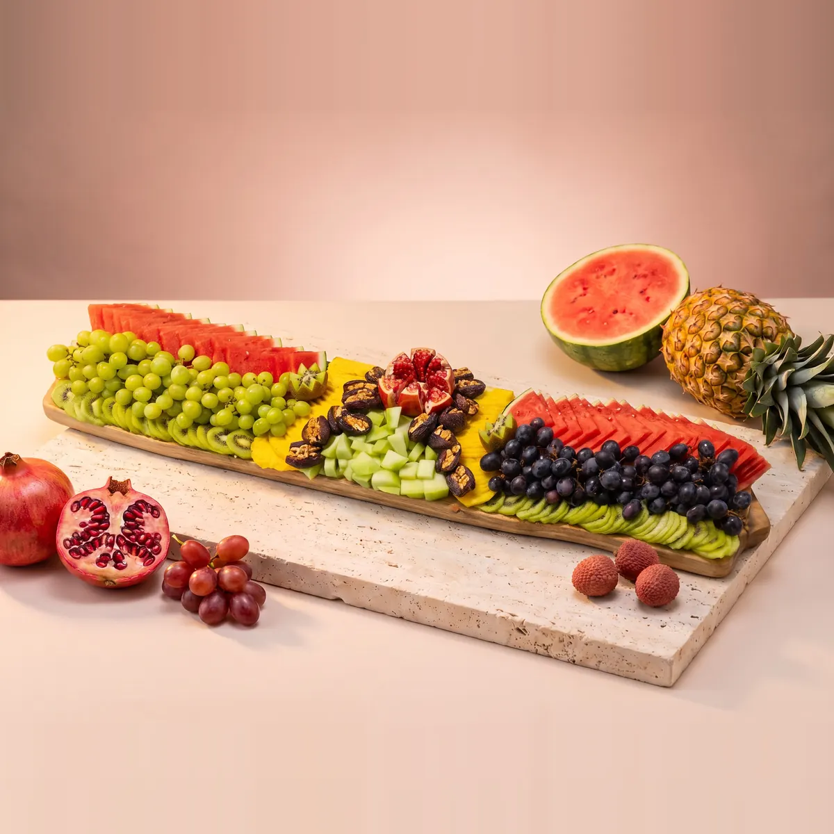 The Extra large platter: a very long board in rows of green grapes, watermelon, dates, pomegranate, dark grapes and kiwi