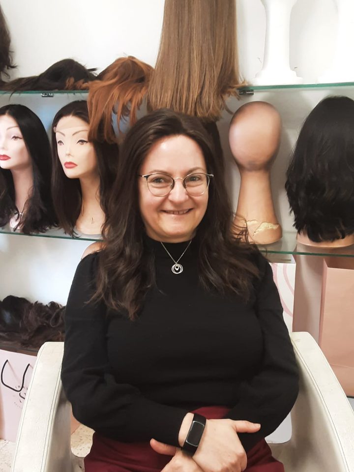 A client with glasses in a dark shoulder-length wig