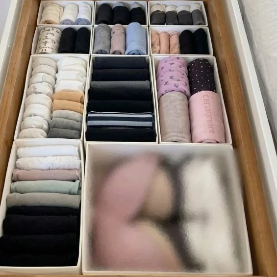 The same drawer with clothes rolled in separate compartments