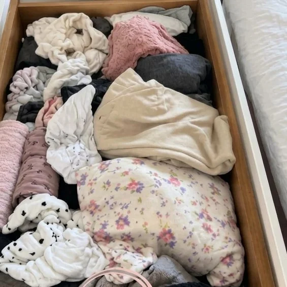 A clothes drawer packed with loose clothes