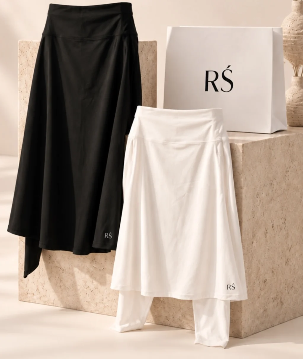 A black and a white RS sports skirt on a stone plinth beside an RS bag