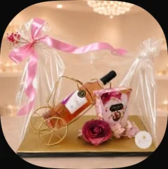 A gold bicycle wine holder with a bottle and a rose, wrapped in cellophane
