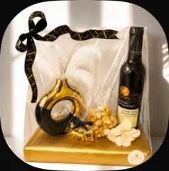 A black and gold vase with a bottle and towels on a gold board