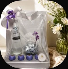 A small glass jar with candles and a bottle, wrapped with a purple ribbon