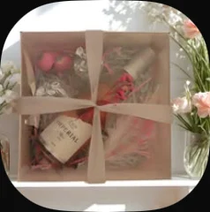 L'Chaim cups and a bottle in a clear box tied with a ribbon