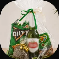 A bottle opener with a bottle and snacks, wrapped in cellophane with a green ribbon