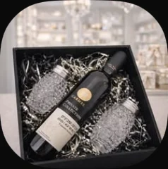 Two glass salt shakers and a bottle in a black box